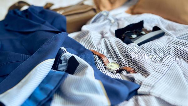 Clothes and accessories laid out on bed. 