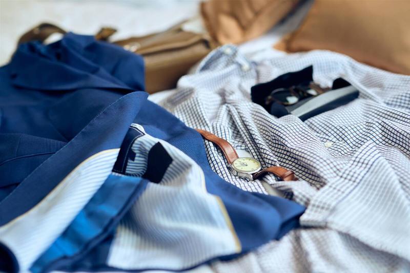 Clothes and accessories laid out on bed. 