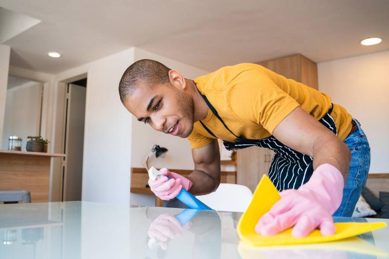 Man cleaning stains off of a table. 