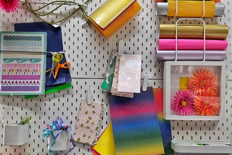 Pegboard holding colorful crafting supplies. 