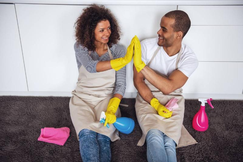 Man and woman high-fiving after cleaning. 