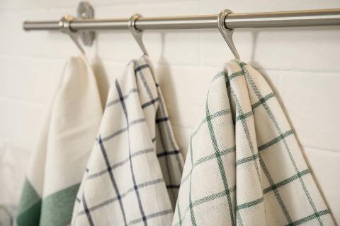 Different kitchen towels hanging on rack.