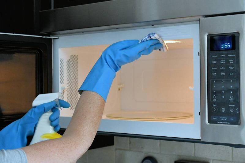 Person cleaning inside of a microwave. 