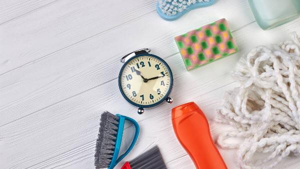 House cleaning products around a vintage analogue clock. 