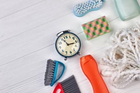 House cleaning products around a vintage analogue clock. 