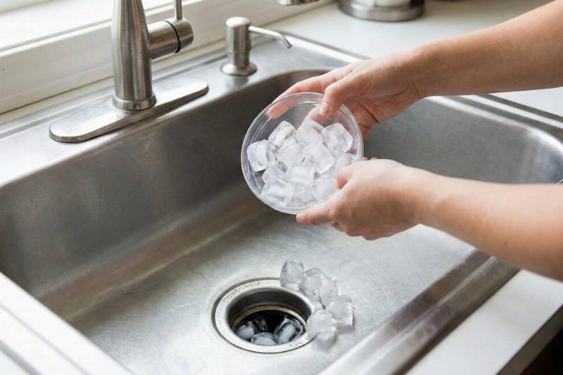 A person pouring ice down the drain. 