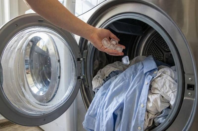 Hands putting ice cubes in a dryer. 