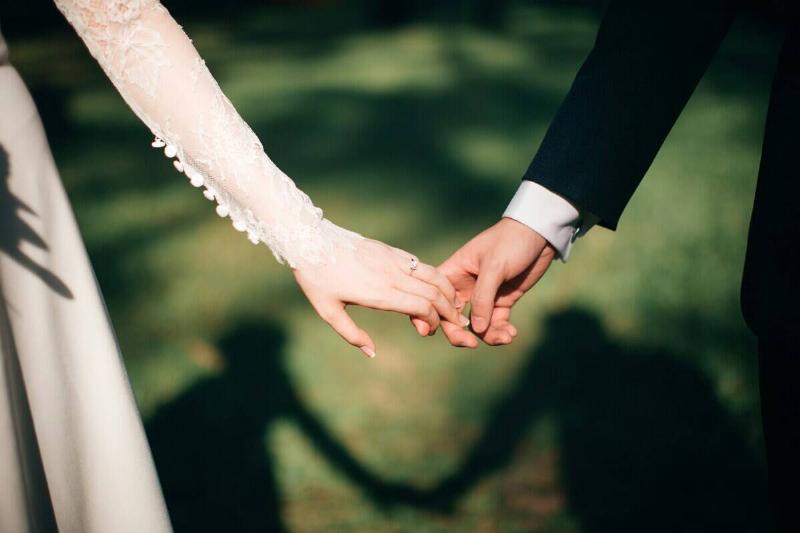 Close-up of a bride and groom holding hands