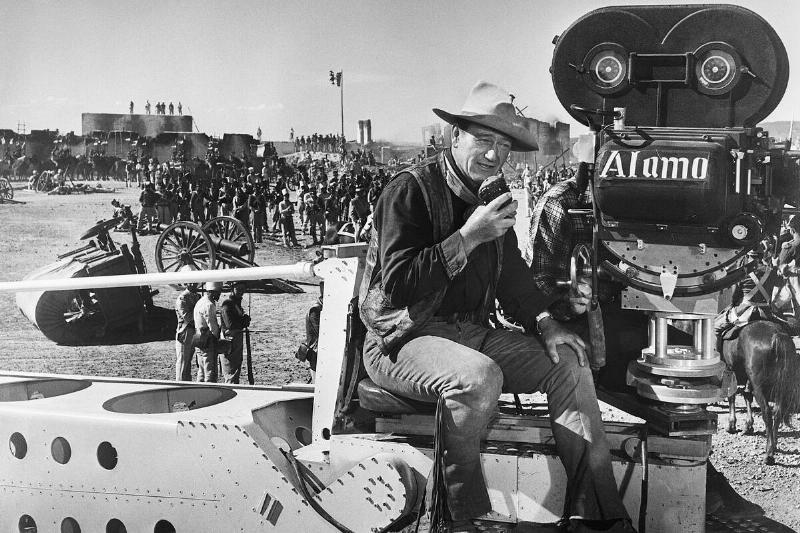John Wayne sitting on the set of 'The Alamo'
