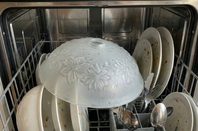 A glass light fixture inside of a dishwasher.