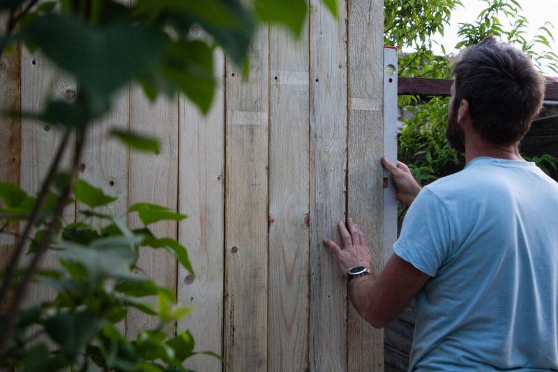 Man building a wooden fence.