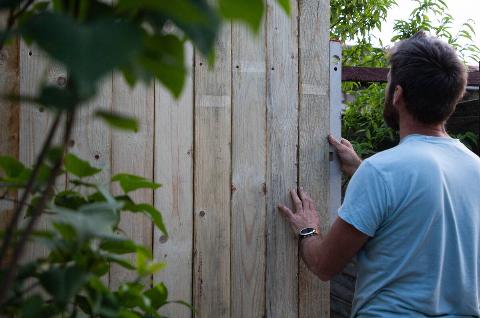 Man building a wooden fence.