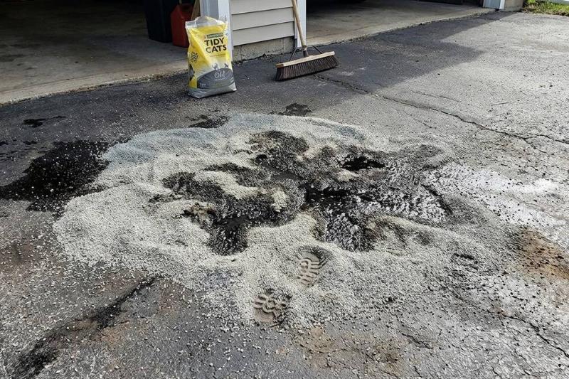 Kitty litter soaking up an oil spill on a driveway. 