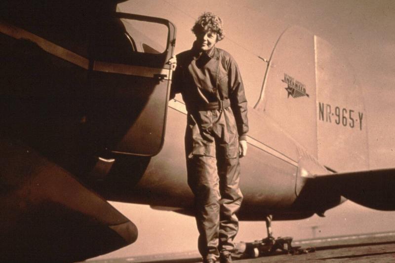 Amelia Earhart holding the cockpit door to her airplane open