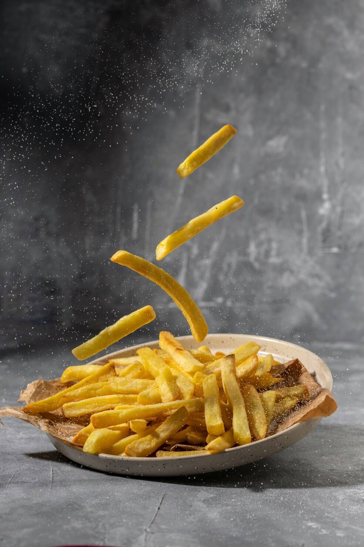 French fries dropping onto a plate