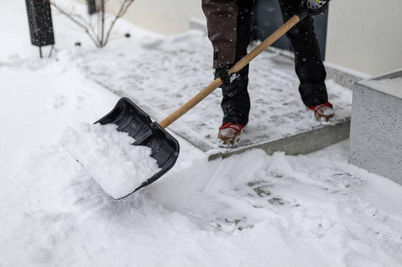 Snow on a snow shovel as someone tries to clear their driveway. 