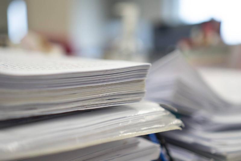 Stacks of paper on a desktop.