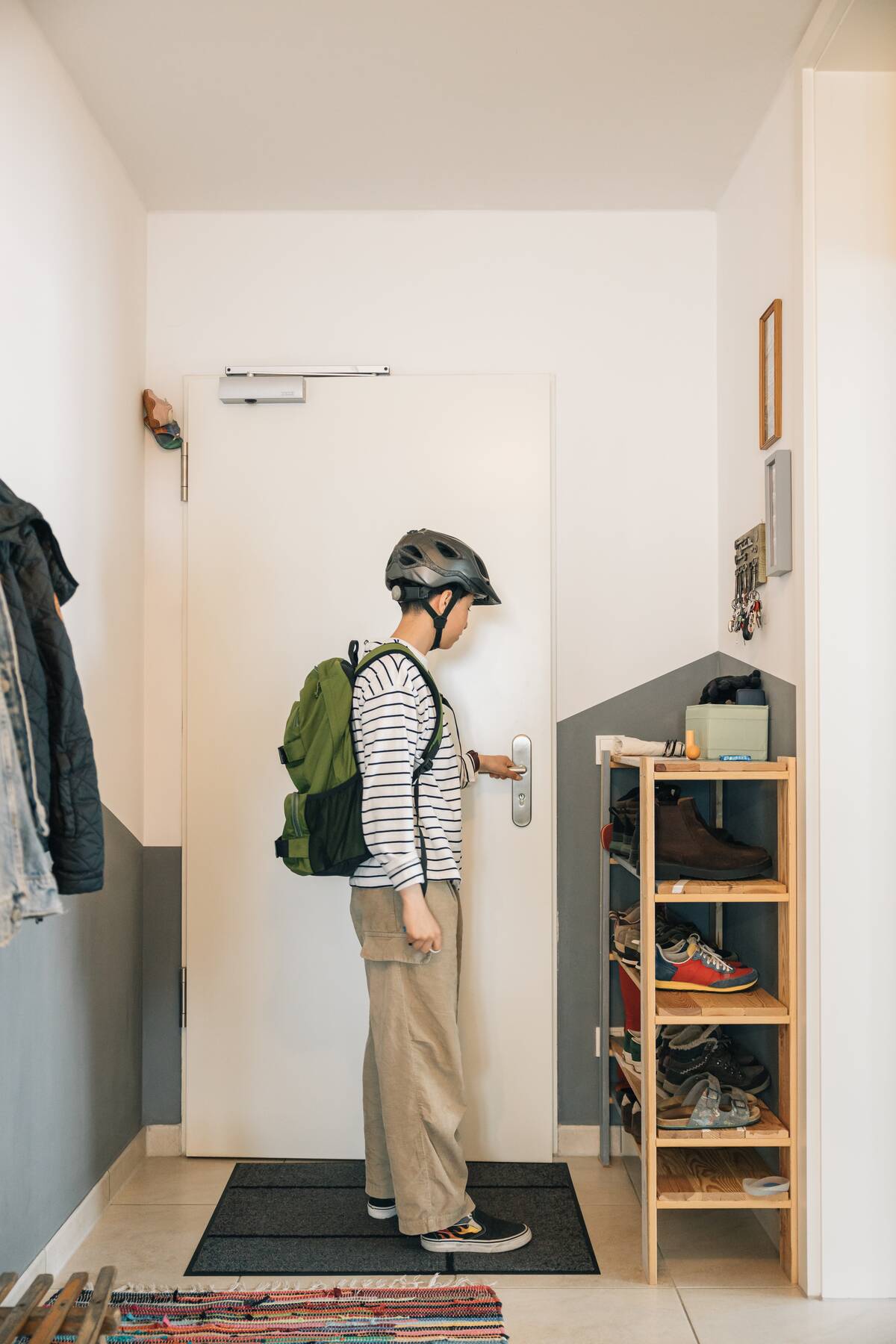 Девушка-подросток в велосипедном шлеме и зеленом рюкзаке-2025-01-10-07-01-35-utc Человек возвращается домой в квартиру.