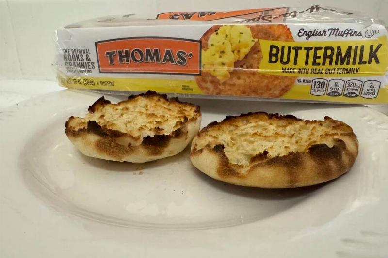Toasted Thomas' English muffin cut in half on a plate. The package is placed behind the pieces