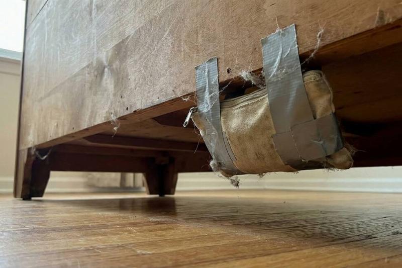 A pouch of valuables taped to the underside of a heavy dresser. 