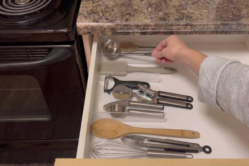 Clear picture frames used to organize kitchen utensils. 