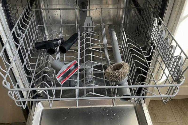 Vacuum attachments on the top shelf of a dishwasher. 