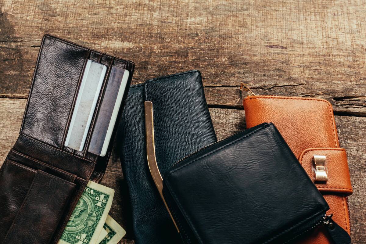 Open leather wallet on wooden table. 