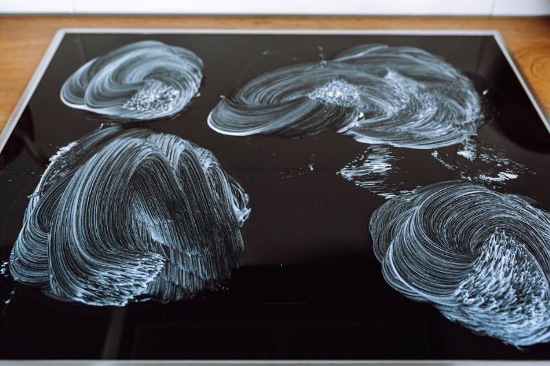 Ceramic stovetop being cleaned. 