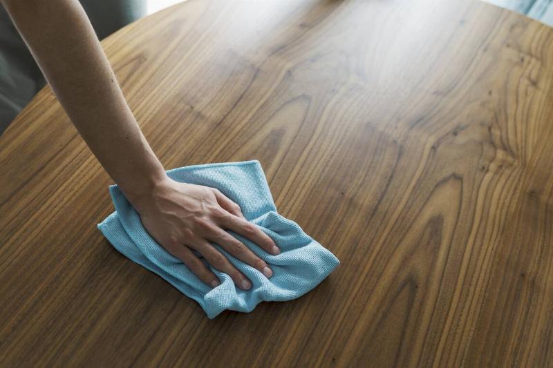 Woman polishing wood table. 