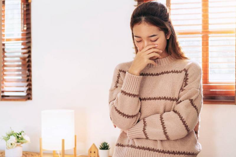 Woman covering nose against bad smell. 