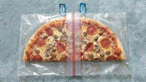 Two Ziplock bags connected to hold half of a pizza.