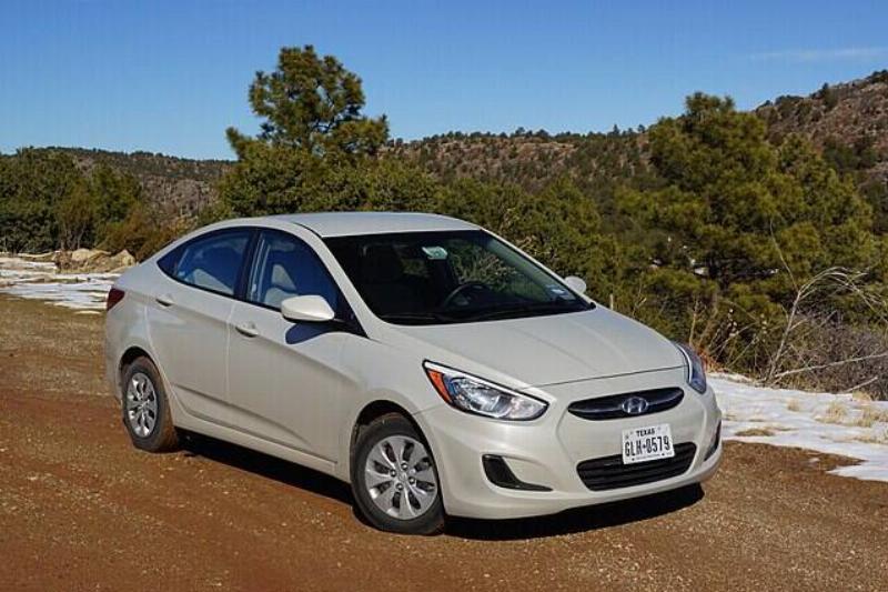 Beige 2015 Hyundai Accent parked on a dirt road