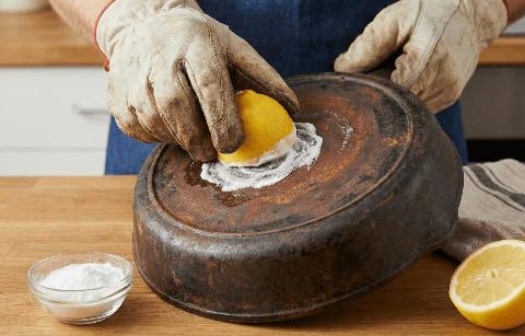 Scrubbing a pan with a lemon and baking soda. 