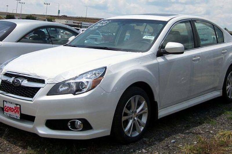 White 2013 Subaru Legacy parked on a lot, next to another vehicle
