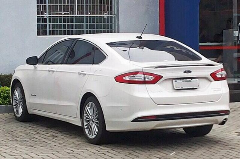 White 2014 Ford Fusion parked outside of a building