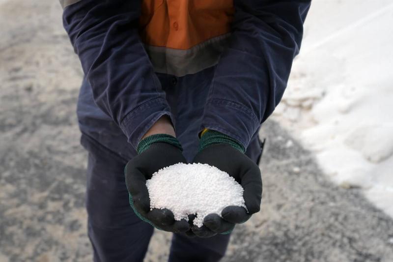 A person holding calcium chloride pellets. 