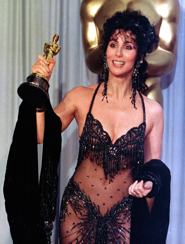 Cher holding up her Academy Award