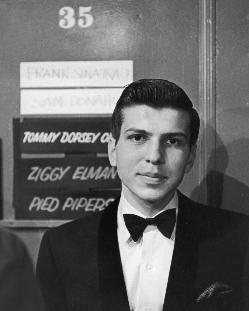 Frank Sinatra, Jr. standing in front of a door