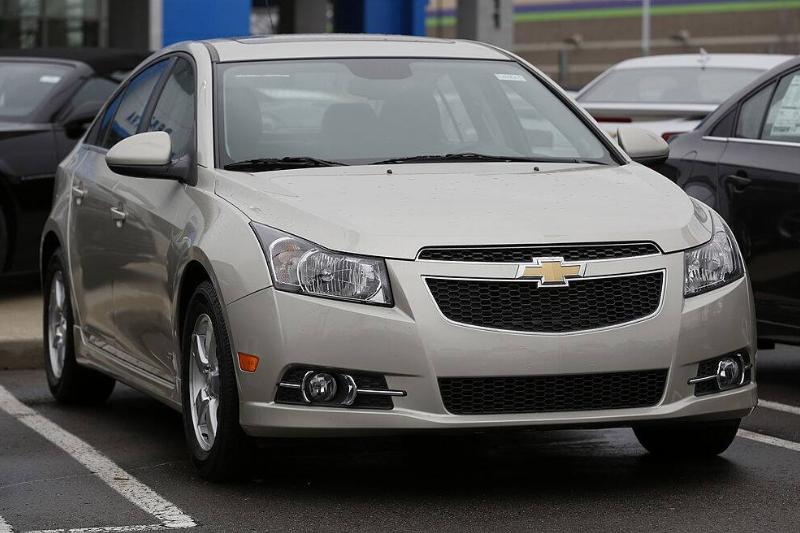 Silver 2014 Chevrolet Cruze parked in a spot, next to another vehicle