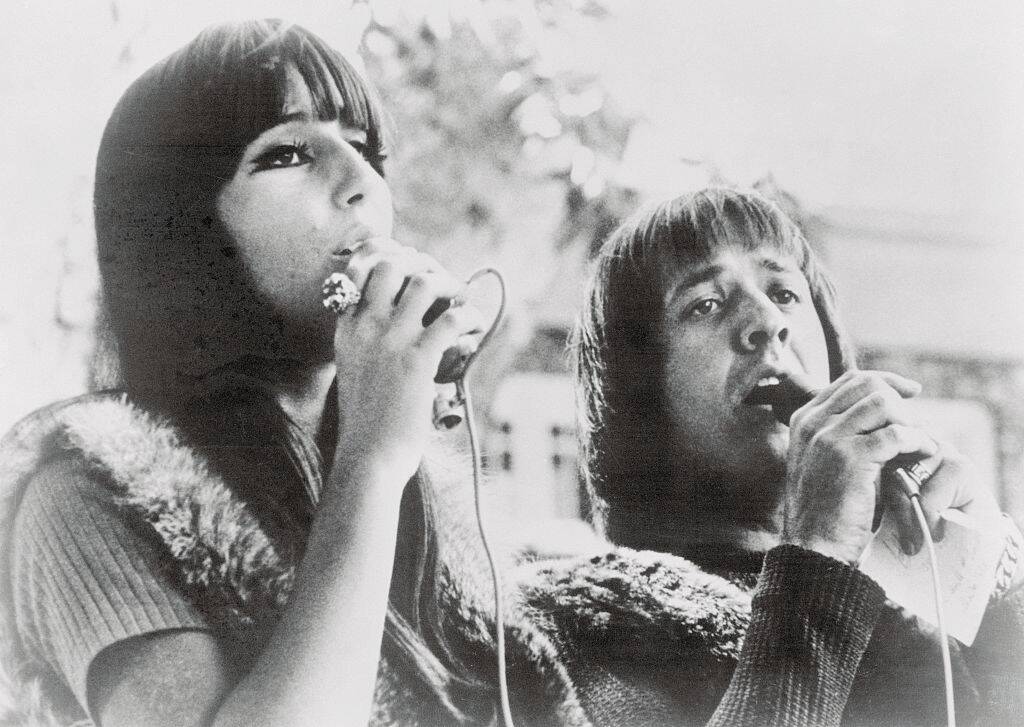 Cher and Sonny Bono singing together outside
