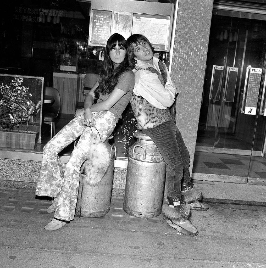 Sonny Bono and Cher sitting together in a restaurant