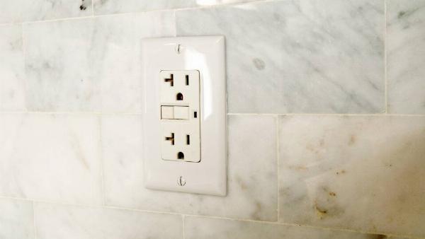 A wall socket in a bathroom. 