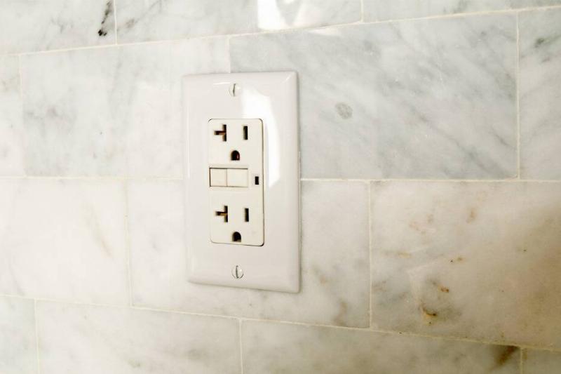 A wall socket in a bathroom. 