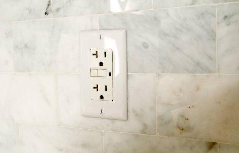 A wall socket in a bathroom. 