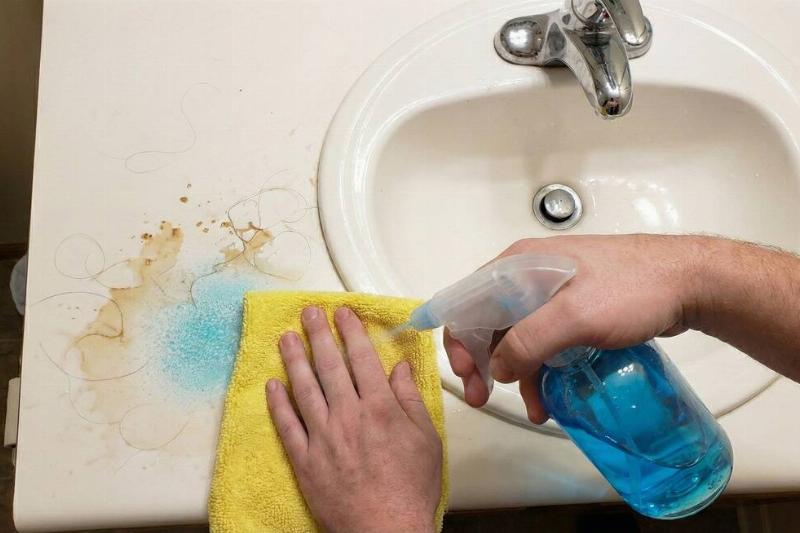 The dish soap cleaner sprayed on a bathroom counter from a spray bottle. 