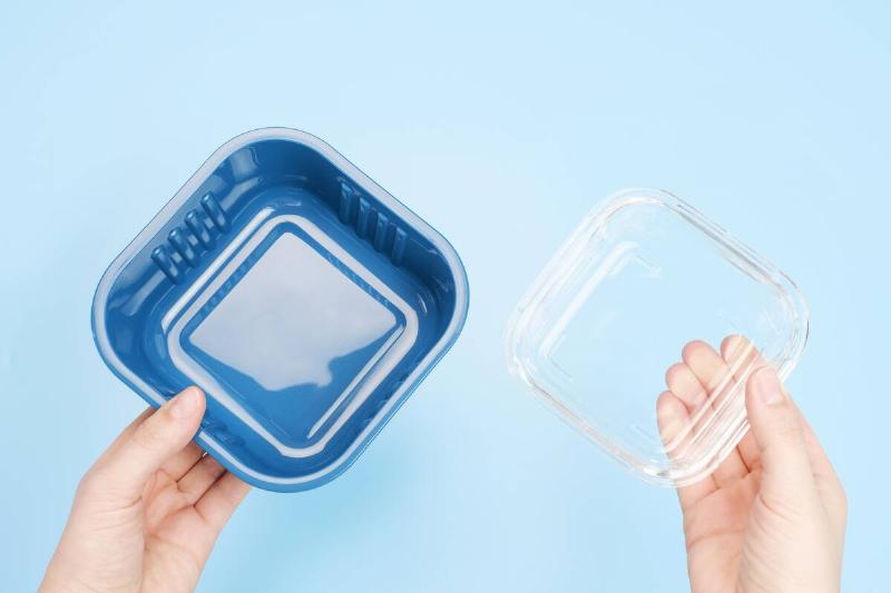 Person holding two containers without lids. 