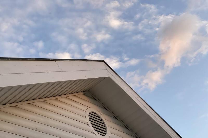 A vent in an attic on the exterior of a house. 
