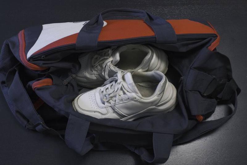 Dirty gym bag with white shoes in it. 
