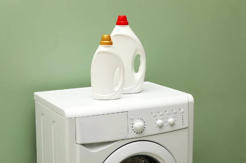 Bottles of laundry detergent on top of a dryer. 