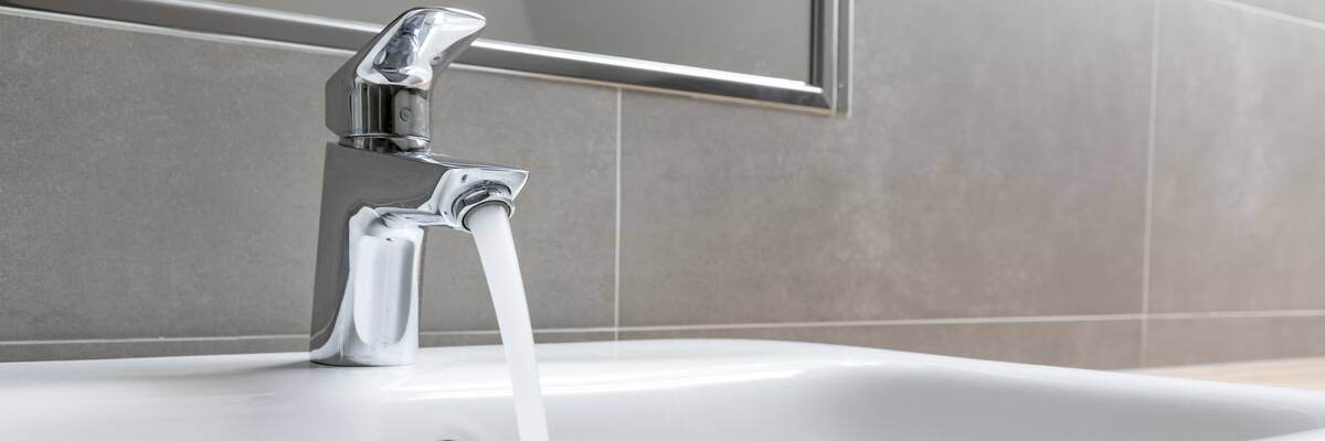 Water coming out of a chrome faucet. 